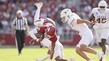 Nov 16, 2024; Fayetteville, Arkansas, USA; Arkansas Razorbacks quarterback Taylen Green (10) is tackled by Texas Longhorns defensive back Jaylon Guilbeau (3) as linebacker Liona Leaf (18) defends during the fourth quarter at Donald W. Reynolds Razorback Stadium. Texas won 20-10. Mandatory Credit: Nelson Chenault-Imagn Images