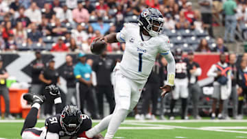 Sep 28, 2025; Houston, Texas, USA; Tennessee Titans quarterback Cam Ward (1) scrambles from Houston Texans defensive end Will Anderson Jr. (51) during the first half at NRG Stadium. Mandatory Credit: Troy Taormina-Imagn Images