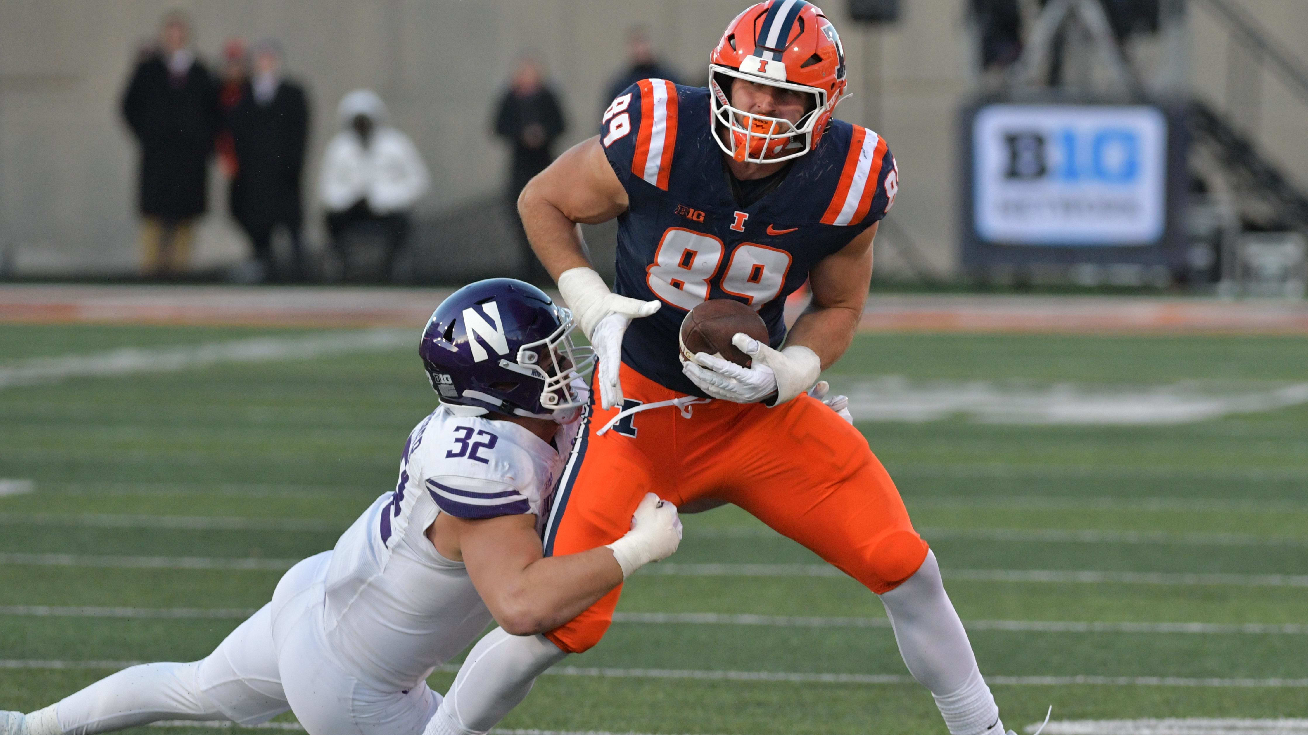 Illinois Fighting Illini tight end Tip Reiman (89) makes a catch with a defender draped over him.