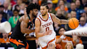 Mar 26, 2023; Kansas City, MO, USA; Texas Longhorns forward Timmy Allen (0) dribbles the ball against Miami (Fl) Hurricanes forward Norchad Omier (15) during the second half of an Elite 8 college basketball game in the Midwest Regional of the 2023 NCAA Tournament at T-Mobile Center. Mandatory Credit: Jay Biggerstaff-Imagn Images