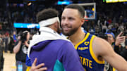Feb 23, 2024; San Francisco, California, USA; Golden State Warriors guard Stephen Curry (right) hugs Charlotte Hornets guard Seth Curry (left) after the game at Chase Center. Mandatory Credit: Darren Yamashita-Imagn Images