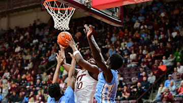 Mar 4, 2025; Blacksburg, Virginia, USA;  Virginia Tech Hokies guard Tyler Johnson (10) goes up for a shot as North Carolina Tar Heels forward Jalen Washington (13) defends during the first half at Cassell Coliseum. Mandatory Credit: Brian Bishop-Imagn Images