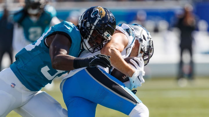 Dec 31, 2023; Jacksonville, Florida, USA; Jacksonville Jaguars linebacker Devin Lloyd (33) tackles Carolina Panthers wide receiver Adam Thielen (19) during the first quarter at EverBank Stadium. Mandatory Credit: Morgan Tencza-USA TODAY Sports