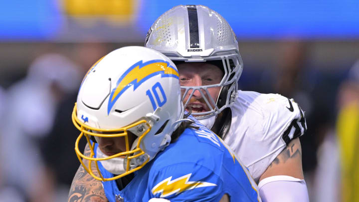 Oct 1, 2023; Inglewood, California, USA;  Los Angeles Chargers quarterback Justin Herbert (10) is sacked by Las Vegas Raiders defensive end Maxx Crosby (98) in the fourth quarter at SoFi Stadium. Mandatory Credit: Jayne Kamin-Oncea-USA TODAY Sports