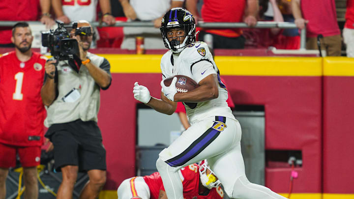 Sep 5, 2024; Kansas City, Missouri, USA; Baltimore Ravens tight end Isaiah Likely (80) scores a touchdown against Kansas City Chiefs safety Bryan Cook (6) during the second half at GEHA Field at Arrowhead Stadium. Mandatory Credit: Jay Biggerstaff-Imagn Images