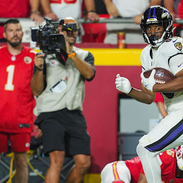 Sep 5, 2024; Kansas City, Missouri, USA; Baltimore Ravens tight end Isaiah Likely (80) scores a touchdown against Kansas City Chiefs safety Bryan Cook (6) during the second half at GEHA Field at Arrowhead Stadium. Mandatory Credit: Jay Biggerstaff-Imagn Images