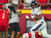 Sep 5, 2024; Kansas City, Missouri, USA; Baltimore Ravens tight end Isaiah Likely (80) scores a touchdown against Kansas City Chiefs safety Bryan Cook (6) during the second half at GEHA Field at Arrowhead Stadium. Mandatory Credit: Jay Biggerstaff-Imagn Images