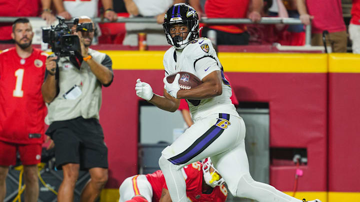 Sep 5, 2024; Kansas City, Missouri, USA; Baltimore Ravens tight end Isaiah Likely (80) scores a touchdown against Kansas City Chiefs safety Bryan Cook (6) during the second half at GEHA Field at Arrowhead Stadium. Mandatory Credit: Jay Biggerstaff-Imagn Images