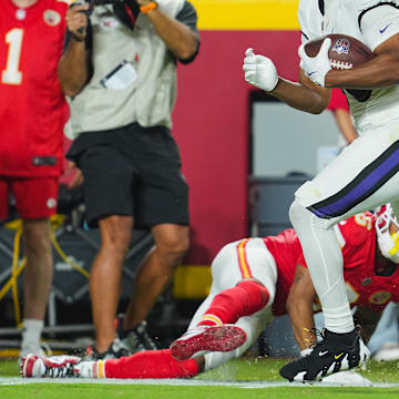 Sep 5, 2024; Kansas City, Missouri, USA; Baltimore Ravens tight end Isaiah Likely (80) scores a touchdown against Kansas City Chiefs safety Bryan Cook (6) during the second half at GEHA Field at Arrowhead Stadium. Mandatory Credit: Jay Biggerstaff-Imagn Images