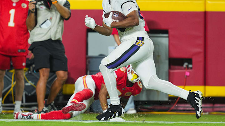 Sep 5, 2024; Kansas City, Missouri, USA; Baltimore Ravens tight end Isaiah Likely (80) scores a touchdown against Kansas City Chiefs safety Bryan Cook (6) during the second half at GEHA Field at Arrowhead Stadium. Mandatory Credit: Jay Biggerstaff-Imagn Images