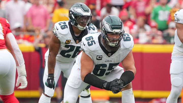 Sep 14, 2025; Kansas City, Missouri, USA; Philadelphia Eagles offensive tackle Lane Johnson (65) and running back Saquon Barkley (26) on the line of scrimmage against the Kansas City Chiefs during the game at GEHA Field at Arrowhead Stadium. Mandatory Credit: Denny Medley-Imagn Images