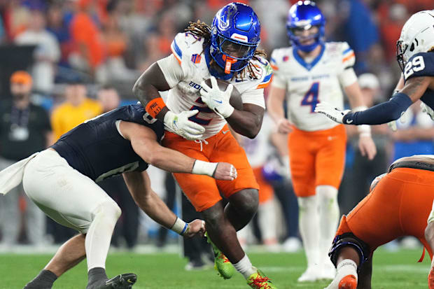 Boise State Broncos running back Ashton Jeanty tries to break past Penn State Nittany Lions linebacker Dominic DeLuca.