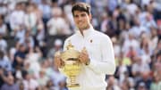 Jul 14, 2024; London, United Kingdom; Carlos Alcaraz of Spain poses with the trophy after winning the men’s singles match against Novak Djokovic of Serbia on day 14 at All England Lawn Tennis and Croquet Club. 