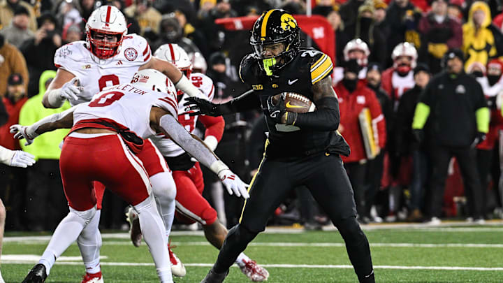 Nov 29, 2024; Iowa City, Iowa, USA; Iowa Hawkeyes running back Kaleb Johnson (2) runs the ball as Nebraska Cornhuskers defensive back DeShon Singleton (8) looks to make the tackle during the third quarter at Kinnick Stadium. Mandatory Credit: Jeffrey Becker-Imagn Images