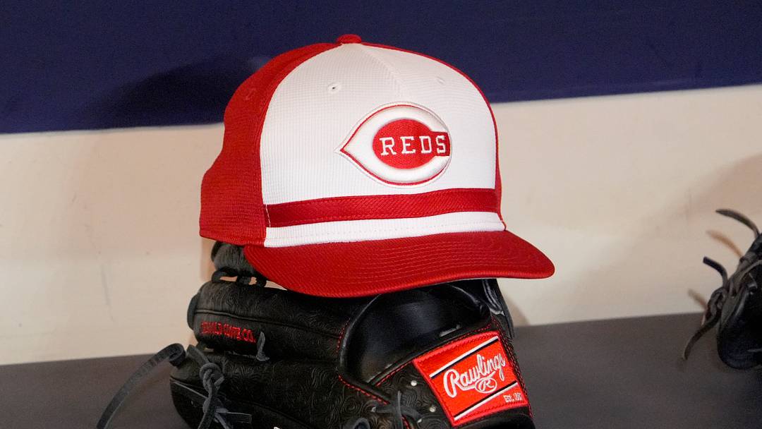 Apr 4, 2025; Milwaukee, Wisconsin, USA; Cincinnati Reds hat and glove rest on the bench in the dugout before a game against the Milwaukee Brewers at American Family Field. Mandatory Credit: Michael McLoone-Imagn Images