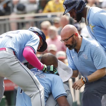 Jun 22, 2024; Pittsburgh, Pennsylvania, USA; Tampa Bay Rays third baseman Amed Rosario (10) is tended to by center fielder Jose Siri (22) and left fielder Randy Arozarena (right) as well as a team trainer after Rosario was hit in the head by a pitch from Pittsburgh Pirates starting pitcher Jared Jones (not pictured) during the first inning at PNC Park.