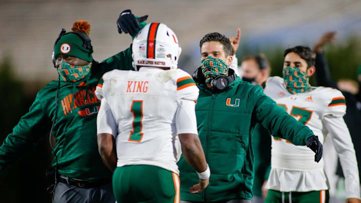 Dec 5, 2020; Durham, North Carolina, USA;  Miami Hurricanes head coach Manny Diaz, right, congratulates Miami Hurricanes quarterback D'Eriq King (1) after a touchdown drive against the Duke Blue Devils in the third quarter at Wallace Wade Stadium. The Miami Hurricanes won 48-0. Mandatory Credit: Nell Redmond-Imagn Images