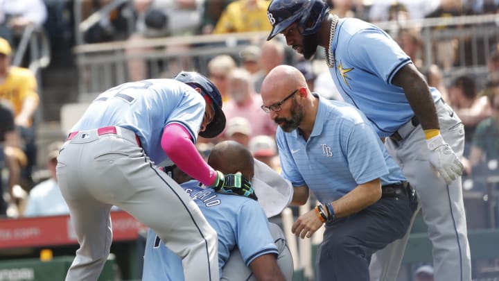 Jun 22, 2024; Pittsburgh, Pennsylvania, USA; Tampa Bay Rays third baseman Amed Rosario (10) is tended to by center fielder Jose Siri (22) and left fielder Randy Arozarena (right) as well as a team trainer after Rosario was hit in the head by a pitch from Pittsburgh Pirates starting pitcher Jared Jones (not pictured) during the first inning at PNC Park.