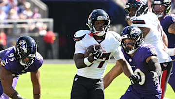 Oct 5, 2025; Baltimore, Maryland, USA; Houston Texans running back Woody Marks (27) runs for a gain past Baltimore Ravens linebacker Tavius Robinson (95) and linebacker Teddye Buchanan (40) during the first quarter at M&T Bank Stadium. Mandatory Credit: Rafael Suanes-Imagn Images