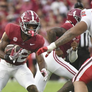 Alabama running back Justice Haynes (22) cuts back against Western Kentucky defensive lineman Jalil Rivera-Harvey (99) during the first half at Bryant-Denny Stadium.  