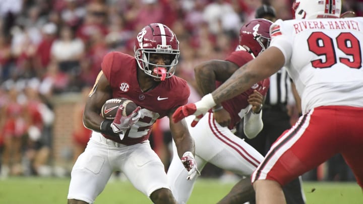 Alabama running back Justice Haynes (22) cuts back against Western Kentucky defensive lineman Jalil Rivera-Harvey (99) during the first half at Bryant-Denny Stadium.  