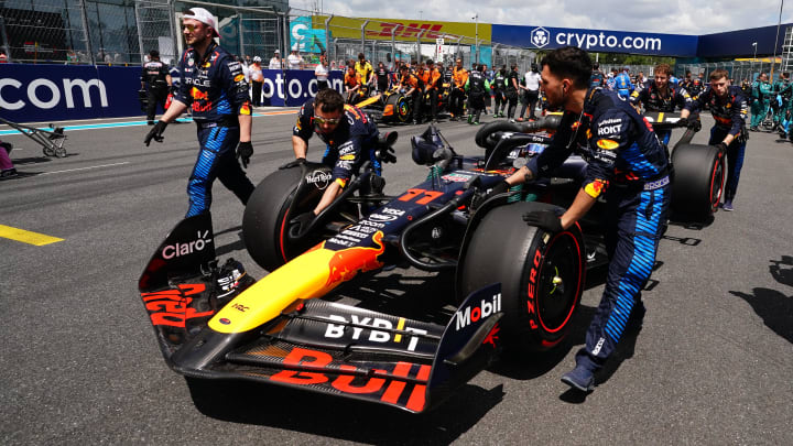 May 4, 2024; Miami Gardens, Florida, USA; Crewmembers push the car of Red Bull Racing driver Sergio Perez (11) on the grid before the F1 Sprint Race at Miami International Autodrome. Mandatory Credit: John David Mercer-USA TODAY Sports