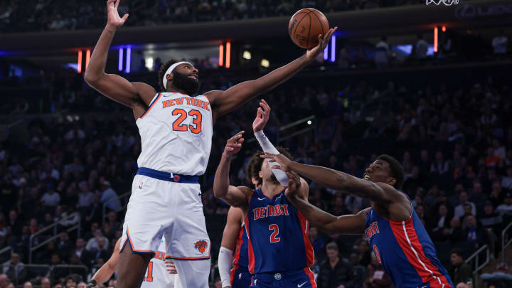 Nov 30, 2023; New York, New York, USA; New York Knicks center Mitchell Robinson (23) rebounds after the game Detroit Pistons guard Cade Cunningham (2) and center Jalen Duren (0) during the first half at Madison Square Garden. Mandatory Credit: Vincent Carchietta-USA TODAY Sports