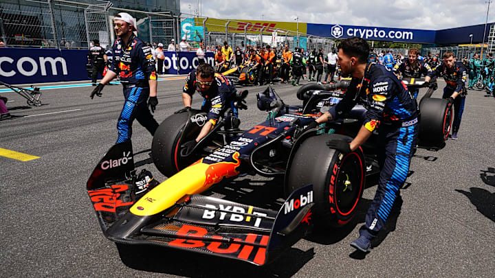 May 4, 2024; Miami Gardens, Florida, USA; Crewmembers push the car of Red Bull Racing driver Sergio Perez (11) on the grid before the F1 Sprint Race at Miami International Autodrome. Mandatory Credit: John David Mercer-Imagn Images