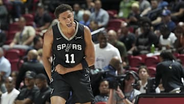 Jul 10, 2025; Las Vegas, NV, USA; San Antonio Spurs forward Carter Bryant (11) reacts to a play against the Philadelphia 76ers in the first quarter of their game at Thomas & Mack Center.