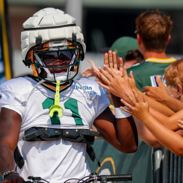 Green Bay Packers wide receiver Jayden Reed slaps hands with fans at training camp on Wednesday.