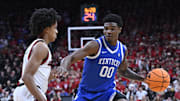 Nov 11, 2025; Louisville, Kentucky, USA;  Kentucky Wildcats guard Otega Oweh (00) dribbles against Louisville Cardinals guard Mikel Brown Jr. (0) during the first half at KFC Yum! Center. Mandatory Credit: Jamie Rhodes-Imagn Images