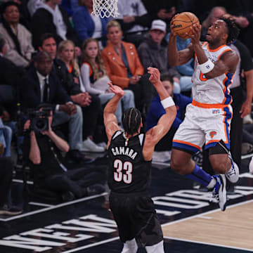 Mar 30, 2025; New York, New York, USA; New York Knicks forward OG Anunoby (8) goes up for a dunk during the first half in front of Portland Trail Blazers center Donovan Clingan (23) and forward Toumani Camara (33) at Madison Square Garden. Mandatory Credit: Vincent Carchietta-Imagn Images