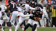 Nov 9, 2025; Chicago, Illinois, USA; Chicago Bears quarterback Caleb Williams (18) avoids the sack by New York Giants linebacker Brian Burns (0) during the second half at Soldier Field.  