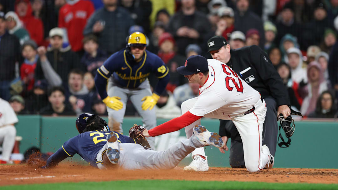 Milwaukee Brewers left fielder Christian Yelich slides past Boston Red Sox relief pitcher Garret Whitlock.