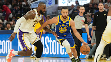 Dec 25, 2024; San Francisco, California, USA; Golden State Warriors guard Stephen Curry (30) dribbles against Los Angeles Lakers forward LeBron James (left) during the third quarter at Chase Center. Mandatory Credit: Darren Yamashita-Imagn Images