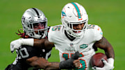 Dec 26, 2020; Paradise, Nevada, USA; Las Vegas Raiders cornerback Damon Arnette (20) tackles Miami Dolphins running back Lynn Bowden (15) during the first half at Allegiant Stadium. Mandatory Credit: Kirby Lee-Imagn Images