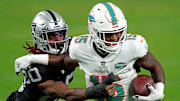 Dec 26, 2020; Paradise, Nevada, USA; Las Vegas Raiders cornerback Damon Arnette (20) tackles Miami Dolphins running back Lynn Bowden (15) during the first half at Allegiant Stadium. Mandatory Credit: Kirby Lee-Imagn Images