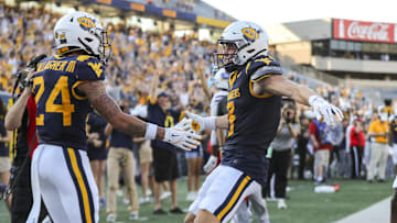 West Virginia Mountaineers wide receiver Rodney Gallagher III (24) celebrates with West Virginia Mountaineers wide receiver Hudson Clement (3) after catching a pass for a touchdown late during the fourth quarter against the Kansas Jayhawks at Mountaineer Field at Milan Puskar Stadium.