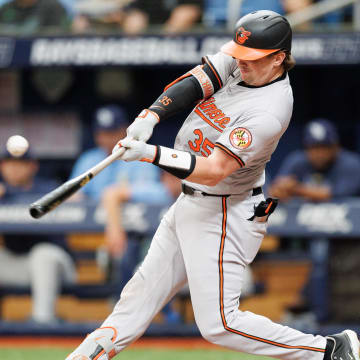 Jun 9, 2024; St. Petersburg, Florida, USA;  Baltimore Orioles catcher Adley Rutschman (35) hits an rbi single against the Tampa Bay Rays in the third inning at Tropicana Field. 