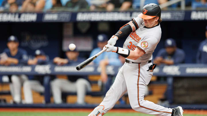 Jun 9, 2024; St. Petersburg, Florida, USA;  Baltimore Orioles catcher Adley Rutschman (35) hits an rbi single against the Tampa Bay Rays in the third inning at Tropicana Field. 