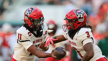 Nov 15, 2025; Miami Gardens, Florida, USA; NC State Wolfpack quarterback CJ Bailey (11) hands off the football to running back Hollywood Smothers (3) during the first quarter at Hard Rock Stadium. Mandatory Credit: Sam Navarro-Imagn Images