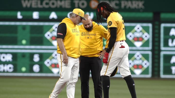 Aug 16, 2024; Pittsburgh, Pennsylvania, USA;  Pittsburgh Pirates manager Derek Shelton (left) and head trainer Rafael Freitas (middle) check on shortstop Oneil Cruz (15) after Cruz suffered an apparent injury running the bases against the Seattle Mariners during the seventh inning at PNC Park. Cruz wuld exit the game. Mandatory Credit: Charles LeClaire-USA TODAY Sports