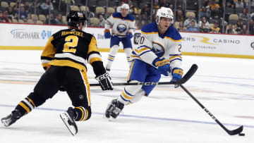 Sep 28, 2023; Pittsburgh, Pennsylvania, USA; Buffalo Sabres center Jiri Kulich (20) moves the puck against Pittsburgh Penguins defenseman Chad Ruhwedel (2) during the first period at PPG Paints Arena. Mandatory Credit: Charles LeClaire-USA TODAY Sports