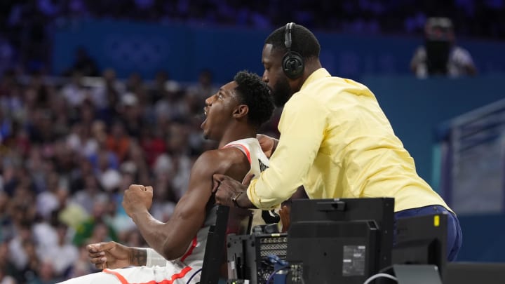 Jul 30, 2024; Villeneuve-d'Ascq, France; Dwyane Wade rubs the shoulders of Canada small forward Rj Barrett (9) against Australia in a men's group stage basketball match during the Paris 2024 Olympic Summer Games at Stade Pierre-Mauroy. Mandatory Credit: John David Mercer-USA TODAY Sports