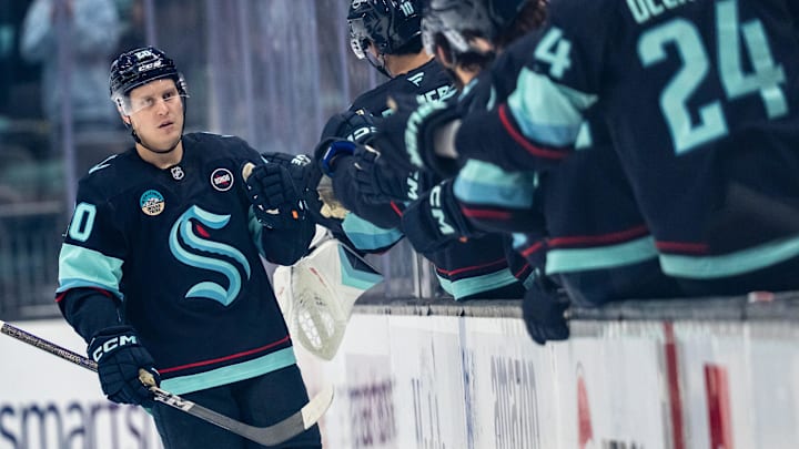 Mar 12, 2025; Seattle, Washington, USA;  Seattle Kraken forward Eeli Tolvanen (20) is congratulated by teammates on the bench after scoring a goal during the second period against the Montreal Canadiens at Climate Pledge Arena. Mandatory Credit: Stephen Brashear-Imagn Images