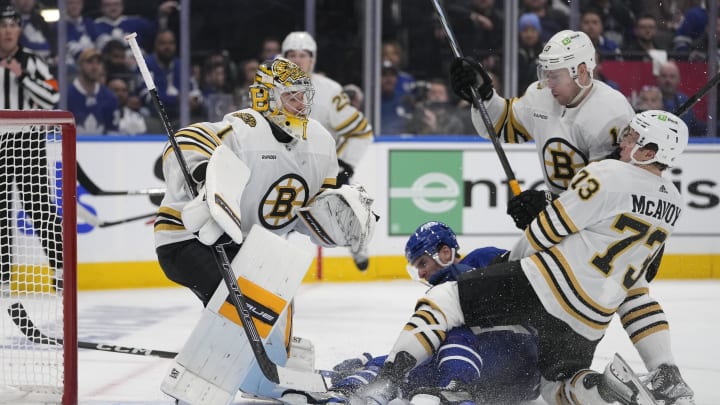 Apr 24, 2024; Toronto, Ontario, CAN; Boston Bruins goaltender Jeremy Swayman (1) looks for the puck as defenseman Charlie McAvoy (73) and forward Charlie Coyle (13) take Toronto Maple Leafs forward John Tavares (91) into the net during the third period of game three of the first round of the 2024 Stanley Cup Playoffs at Scotiabank Arena. Mandatory Credit: John E. Sokolowski-USA TODAY Sports