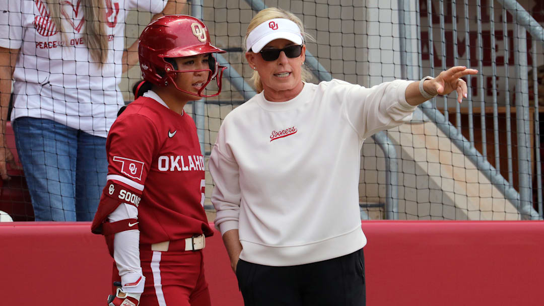 Oklahoma coach Patty Gasso gives directions to Ailana Agbayani between innings in a contest against Kentucky at Love's Field.