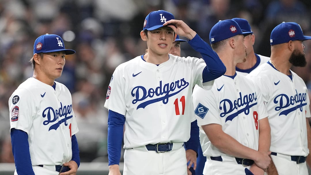 Dodgers pitchers Yoshinobu Yamamoto (left) and Roki Sasaki (11) stand on the field before the game against the Hanshin Tigers at Tokyo Dome. 