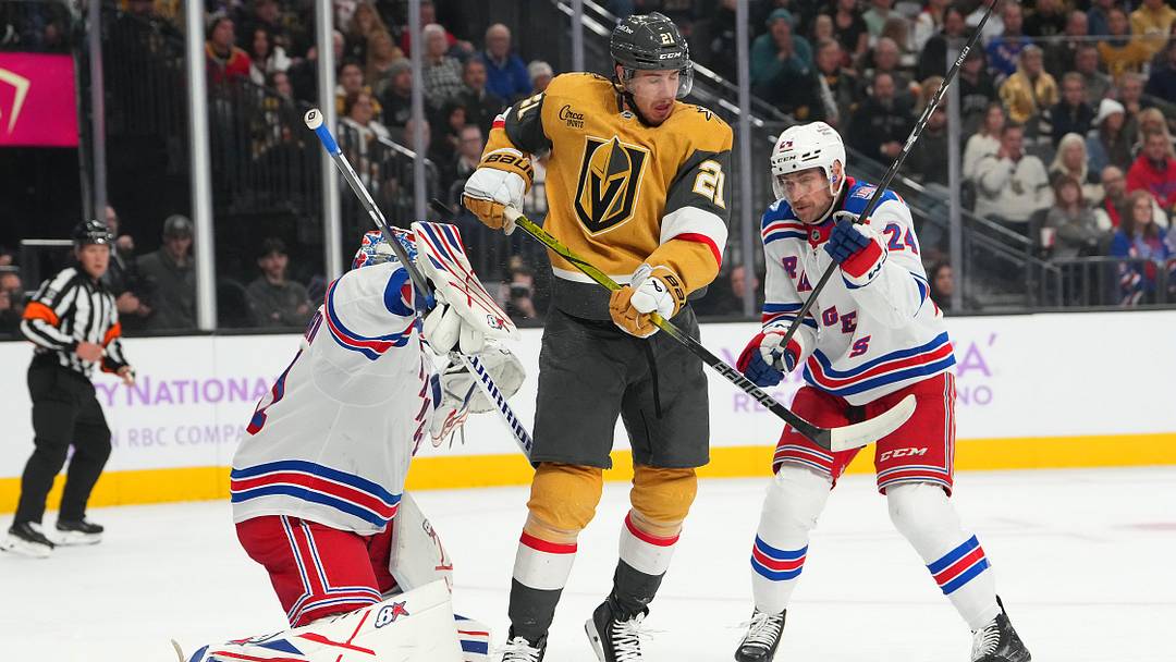 Nov 18, 2025; Las Vegas, Nevada, USA; A shot deflects off Vegas Golden Knights center Brett Howden (21) between New York Rangers goaltender Igor Shesterkin (31) and defenseman Carson Soucy (24) during the first period at T-Mobile Arena. Mandatory Credit: Stephen R. Sylvanie-Imagn Images