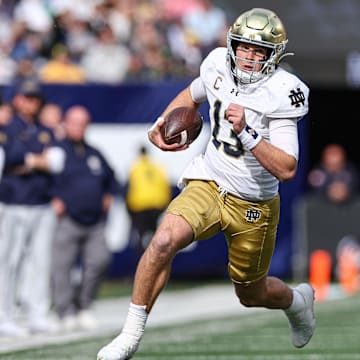 Oct 26, 2024; East Rutherford, New Jersey, USA;Notre Dame Fighting Irish quarterback Riley Leonard (13) carries the ball during the first half against the Navy Midshipmen at MetLife Stadium. Mandatory Credit: Vincent Carchietta-Imagn Images